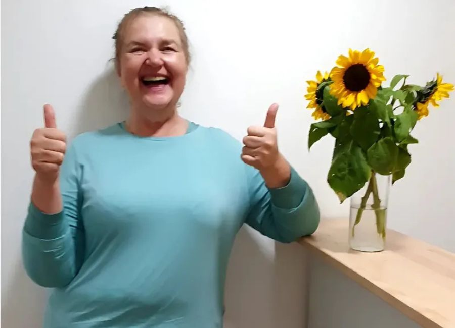 Frau Schaupp vom Pflegedienst AML in Röhrmoos lacht glücklich in die Kamera.