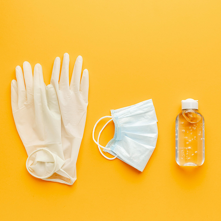 Medizinische Schutzausrüstung, bestehend aus Handschuhen, Maske und Desinfektionsmittel, symbolisiert die Hygiene- und Pflegeprodukte, die durch Pflegegrad 1 bereitgestellt werden.