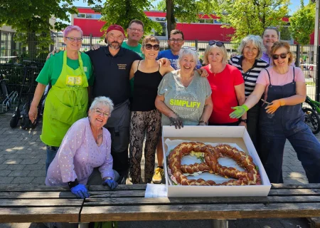 Künstler des Pflegedienstes AML feiern mit einer Brezel ihren Abschlussbeitrag zum Mosaikprojekt in Ingolstadt.