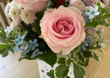 Ein Blumenstrauß mit rosa Rosen und blauen Blumen, als Dankeschön an das Team des Pflegedienstes AML für ihre wertvolle Arbeit.