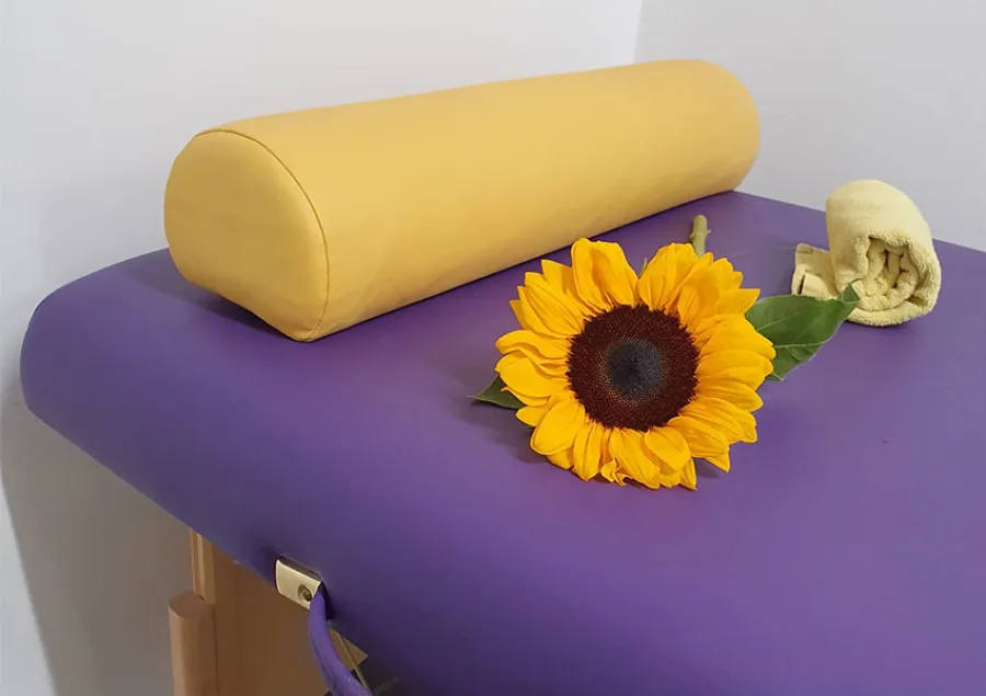 Eine Sonnenblume auf einer Massageliege symbolisiert die entspannenden Massagen für Mitarbeiter beim Pflegedienst AML.